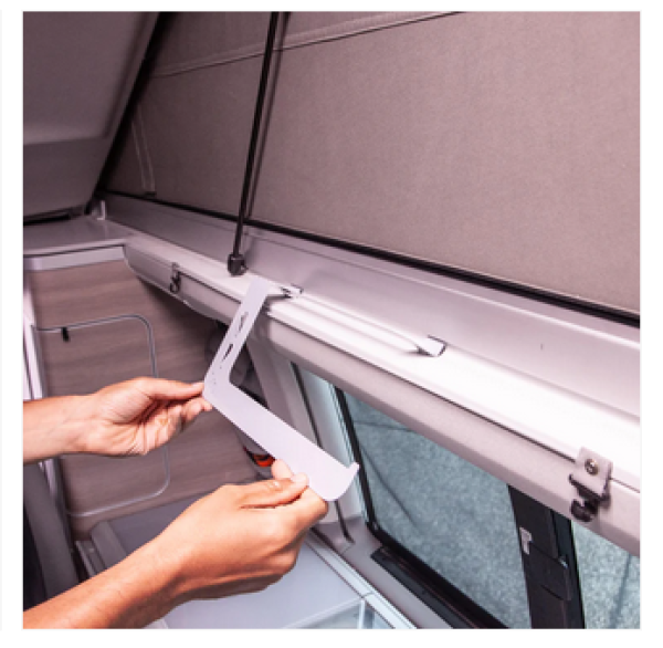 Person montiert Awnlux-Küchenrollenhalter im VW T5/T6 California unter dem Dachrahmen.


